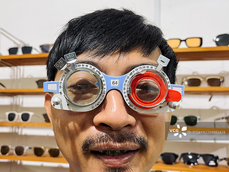 男子在眼镜店试戴验光框图片素材