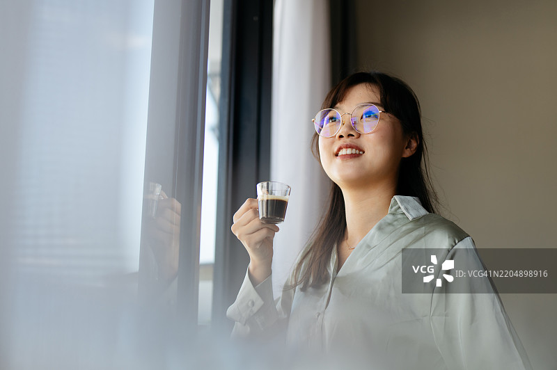 年轻的亚洲女性在家享受黑咖啡图片素材