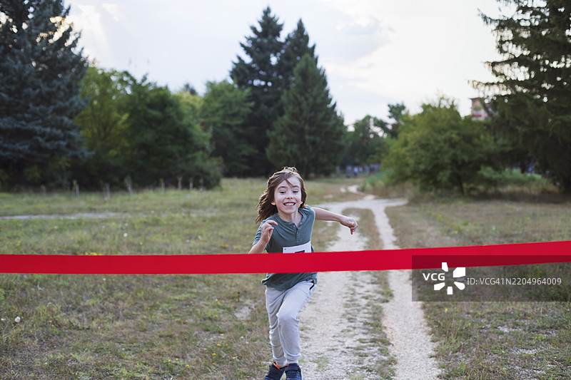 快乐的孩子在比赛中冲过终点线图片素材