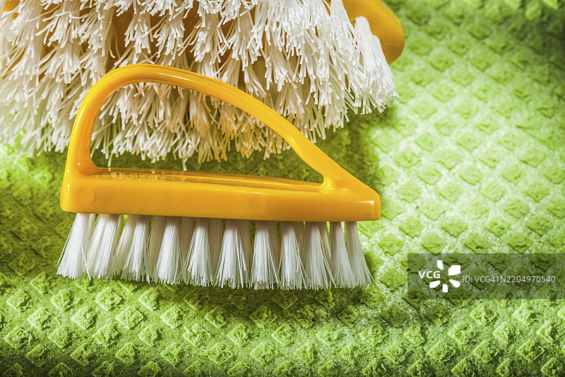 一套新的塑料刷子放在绿色洗涤布上图片素材