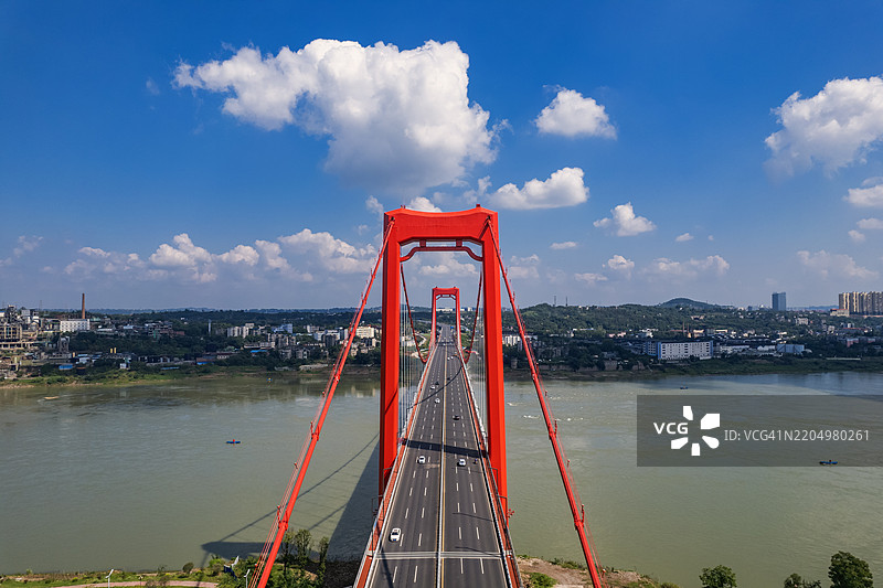 阳光明媚的日子里，四川泸州的红色悬索桥航拍图图片素材