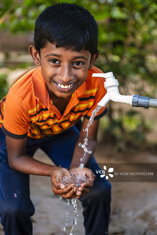 斯里兰卡小男孩在喝水，锡兰图片素材