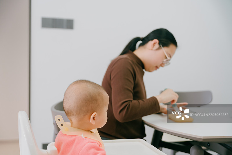 亚洲母亲为婴儿喂食辅食；亚洲家庭生活方式图片素材