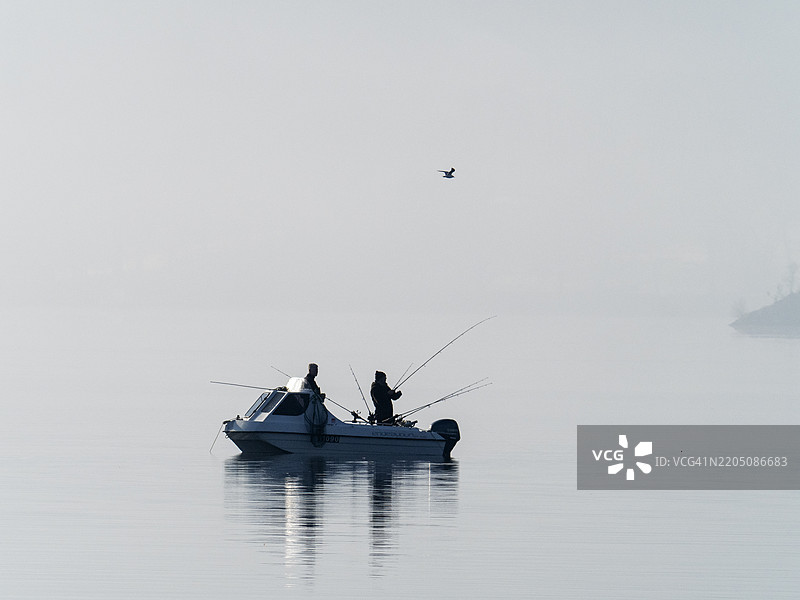 在英国湖区安布尔赛德的温德米尔湖上，男人们在一艘钓鱼船上。图片素材