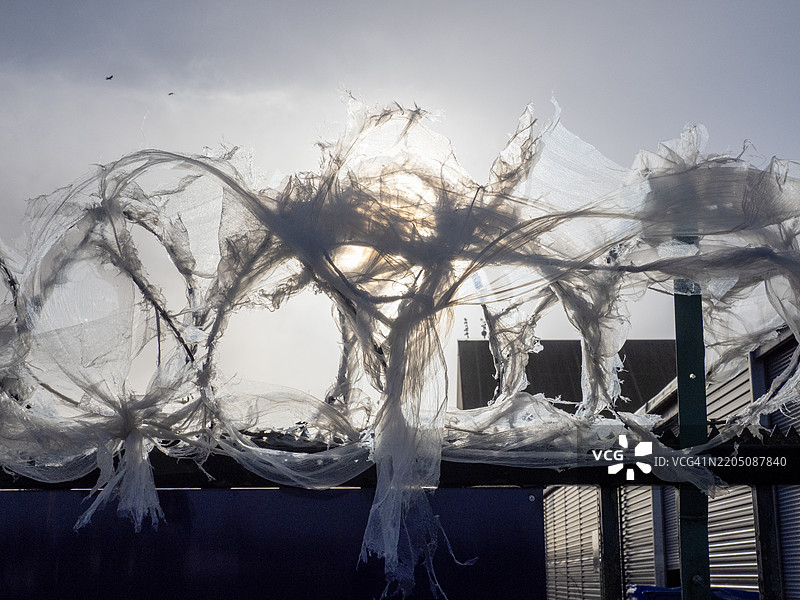 在英国格洛斯特郡塞文河的夏普尼斯码头，塑料收缩包装膜被铁丝网缠住。图片素材