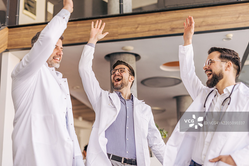 医疗团队在医院庆祝成功，击掌相庆图片素材