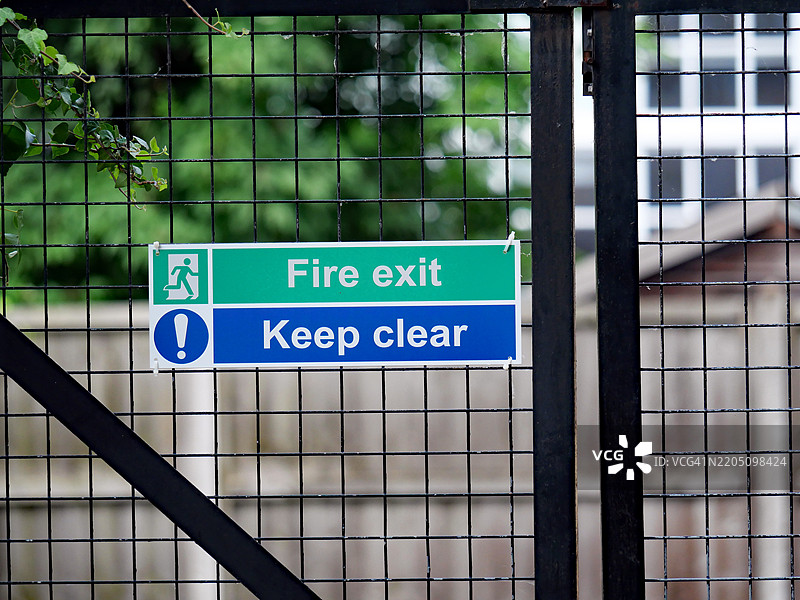 “自由出口 - 请保持通道畅通”标志在一扇门上。伦敦，英格兰，联合王国。自然色彩。阳光照射。图片素材