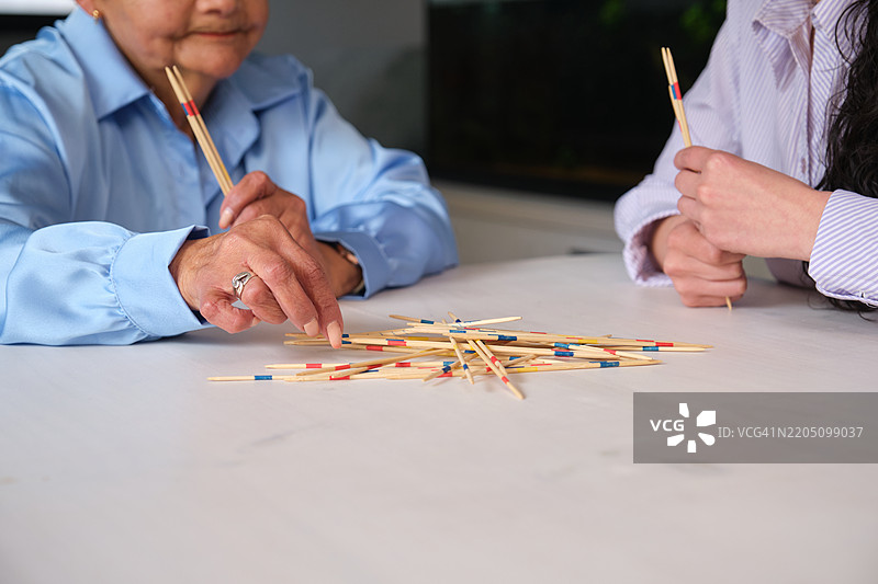 女性在白色桌子上玩米卡多游戏图片素材