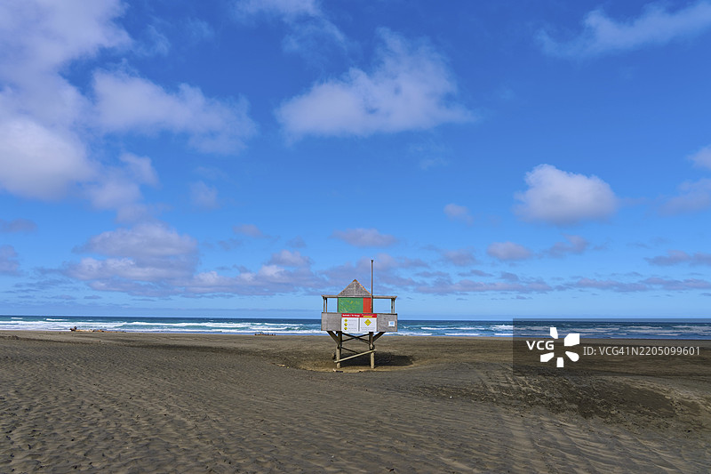 一座救援塔孤独地矗立在宽阔的沙滩上,蓝天映衬下的贝瑟尔斯海滩,特亨加,奥克兰,新西兰,南太平洋图片素材