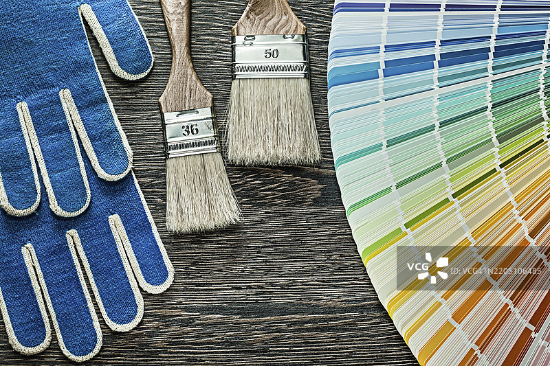 安全手套、油漆刷和潘通色卡放在木板上图片素材
