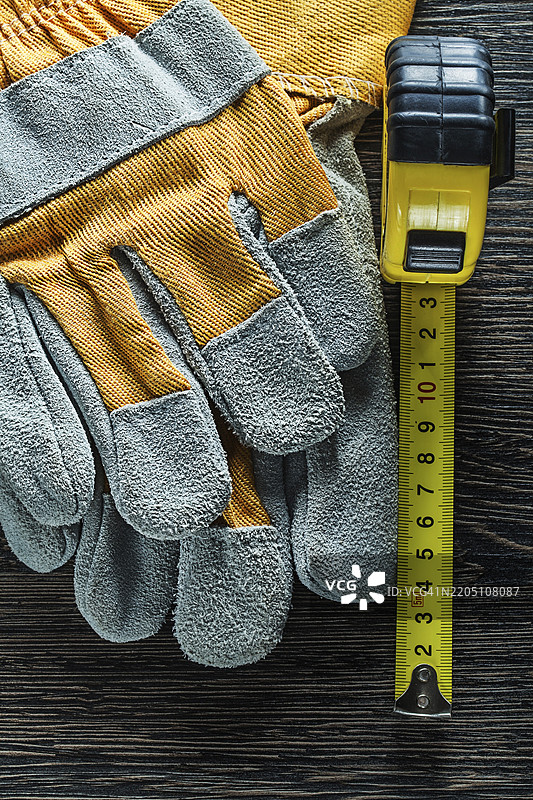一套卷尺保护手套放在木板上图片素材