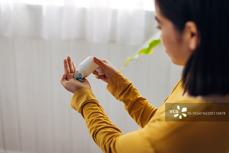 日本女性在家中服用日常药物图片素材
