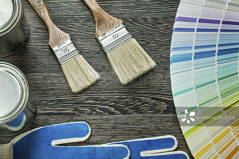 安全手套、油漆刷、油漆罐和潘通色卡放在木板上图片素材