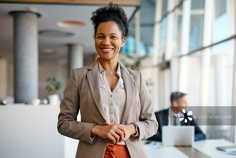 自信的女商人在现代办公室微笑图片素材