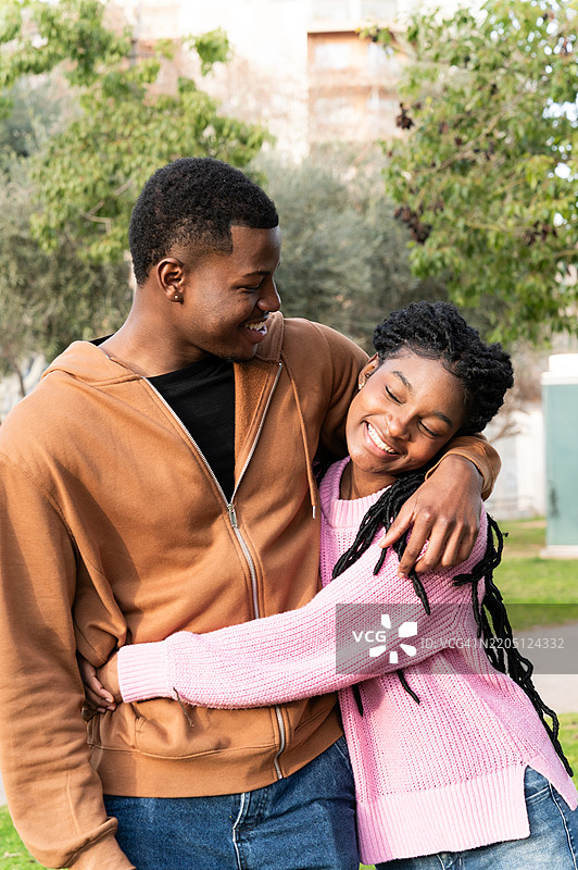 大学校园公园里拥抱的年轻学生情侣图片素材