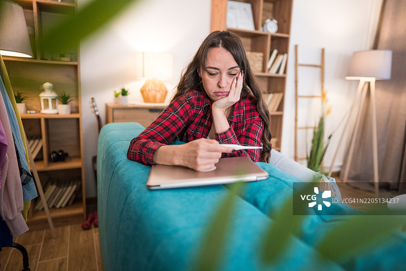 担心的女人用温度计测量体温图片素材