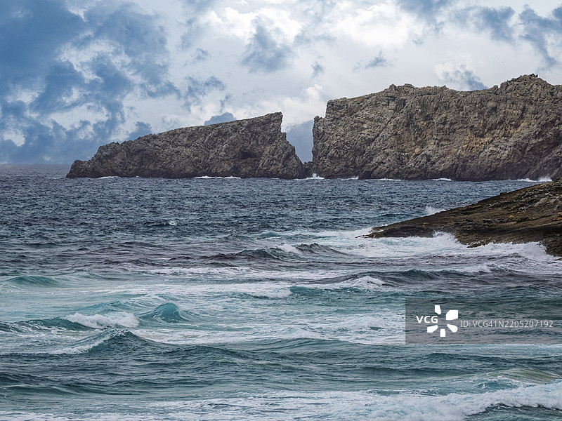 风暴天气下的海滩风景，狂风呼啸，海浪拍打岩石。图片素材