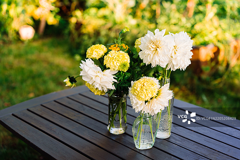 优雅的花卉布置在户外的原木桌上图片素材