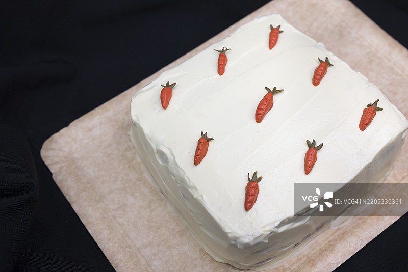 胡萝卜蛋糕配白巧克力和橙味奶油奶酪糖霜，装饰有翻糖胡萝卜图片素材