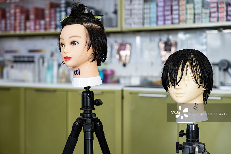 发型师培训用的模特头放在三脚架上。图片素材