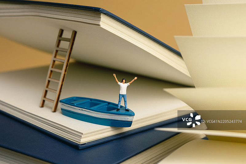 年轻人通过书籍学习 - 微型景观图片素材