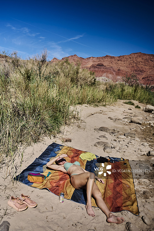 女人在河岸的沙滩上放松休息图片素材