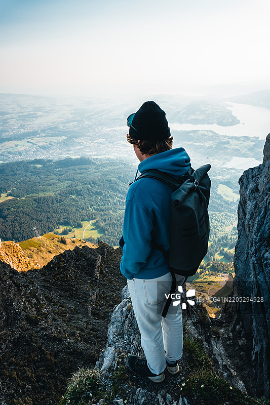 登山者站在湖泊和山脉之上的山顶上图片素材