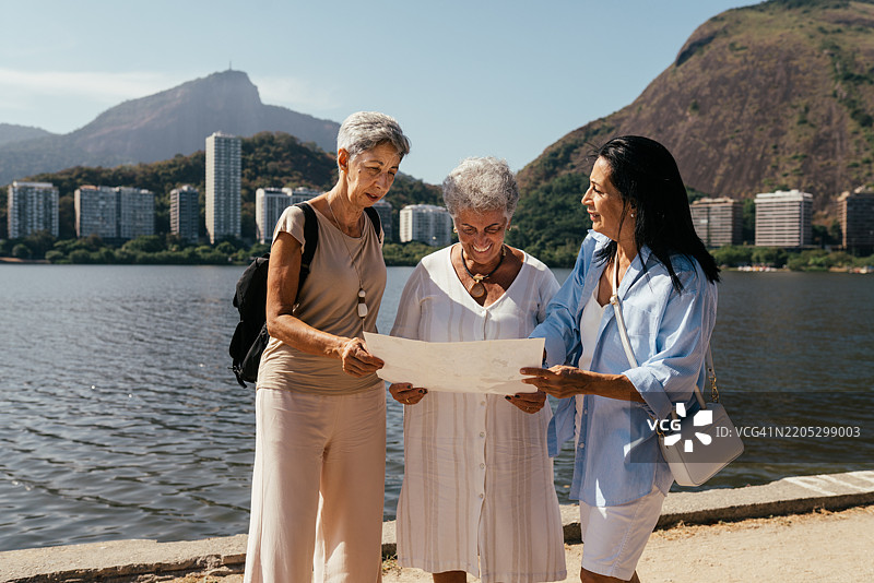 朋友们在罗德里戈·德·弗雷塔斯湖边散步时查看旅游景点地图图片素材