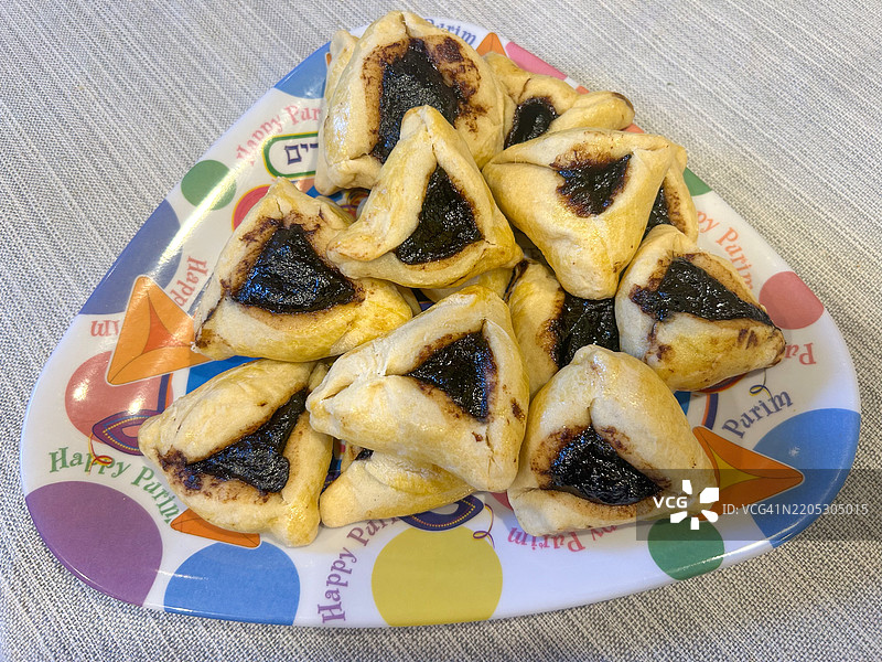 在三角形盘子上堆放的哈曼饼，庆祝犹太节日普林。图片素材