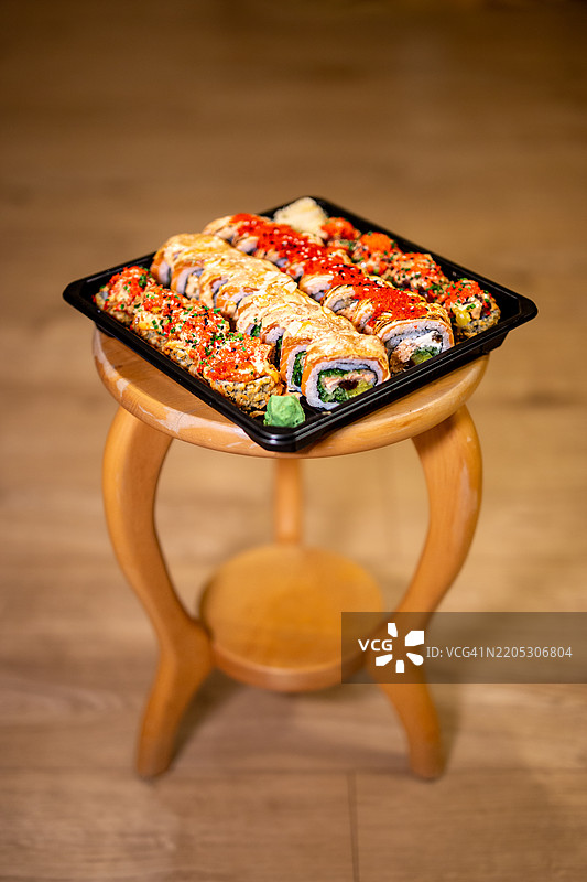 家中木凳上的寿司外卖套餐图片素材