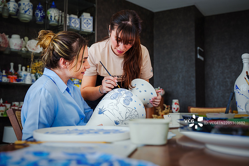 女性在陶瓷工作坊工作，制作手绘花瓶图片素材