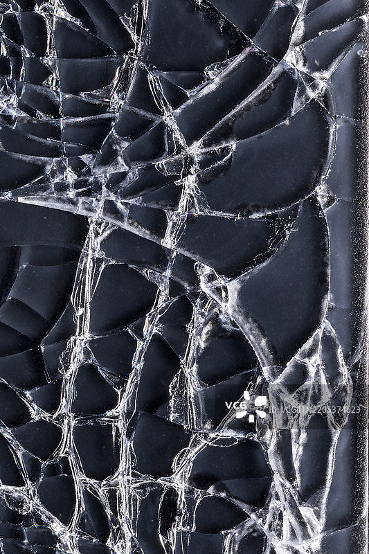 一部智能手机，背面有破碎的玻璃，已经被多辆汽车碾压，导致现代科技黑色触摸屏上布满了许多网状裂纹。破碎玻璃纹理。正在进行抠图处理。图片素材
