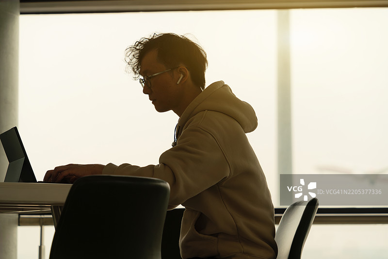商人在机场使用笔记本电脑。图片素材