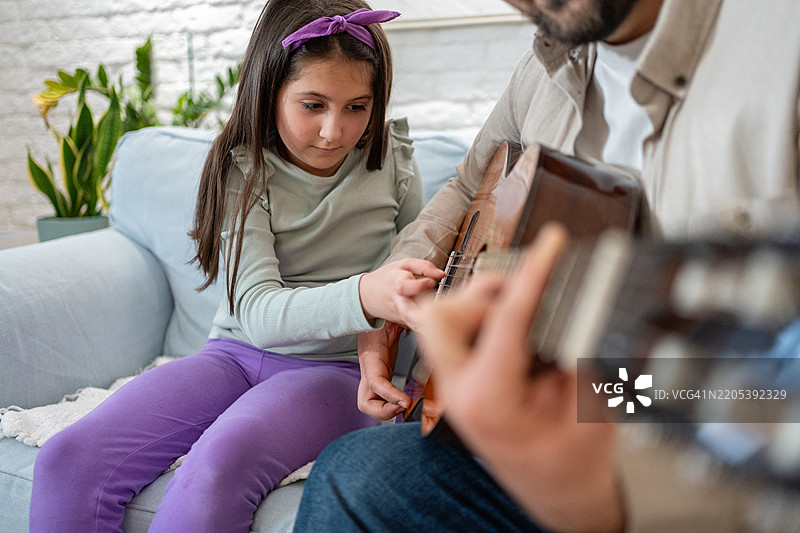 父亲在家中教女儿弹吉他图片素材
