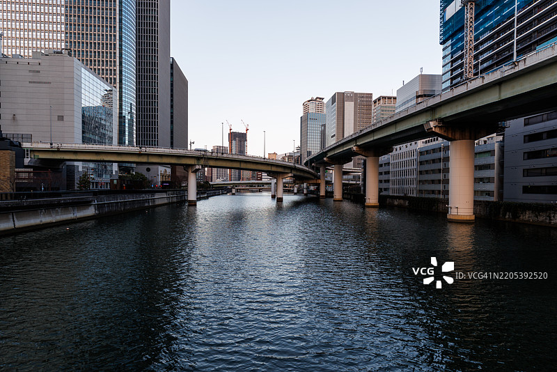 日本大阪中之岛的现代城市与河流的日出图片素材