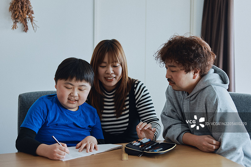 亚洲少年在家与父母一起学习图片素材