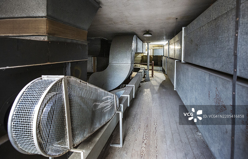 老旧废弃建筑阁楼中的复古金属暖气管道图片素材