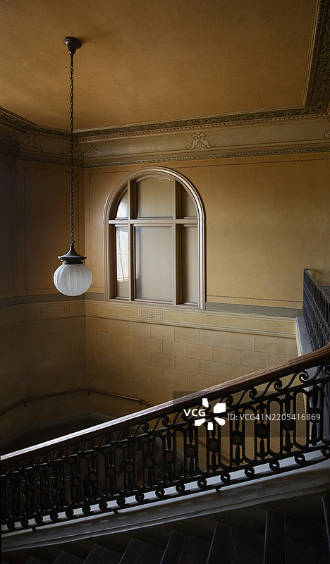 温暖色调的日光照亮了一座老旧废弃建筑的北向楼梯间图片素材