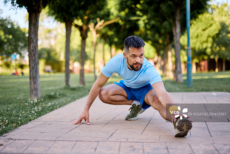 运动员在城市公园里拉伸腿部，为跑步做准备图片素材