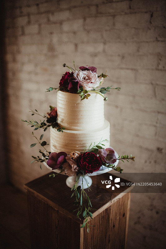 优雅的双层婚礼蛋糕，上面装饰着花朵图片素材