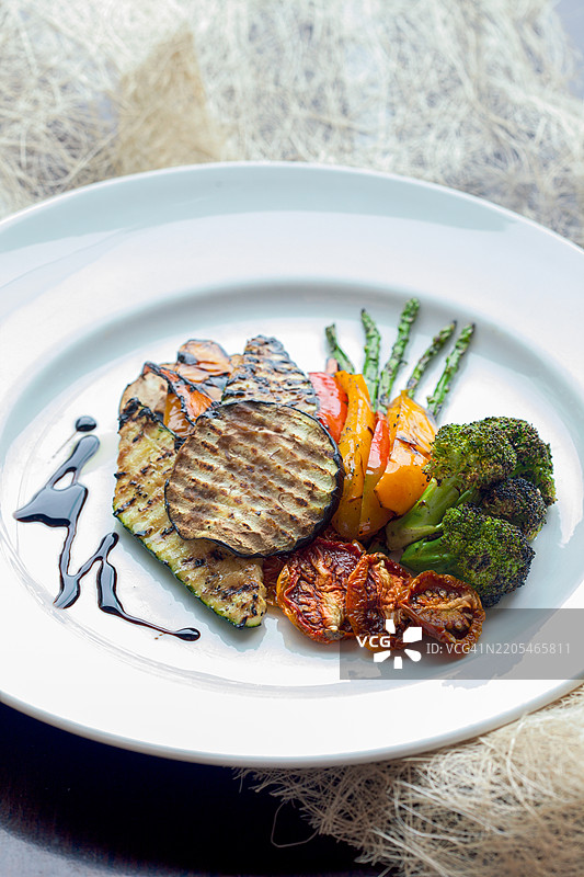 色拉由烤制的彩色甜椒、 zucchini 和茄子组成，搭配新鲜香草和清淡的香醋酱，是一道充满活力且健康的夏季美食。图片素材