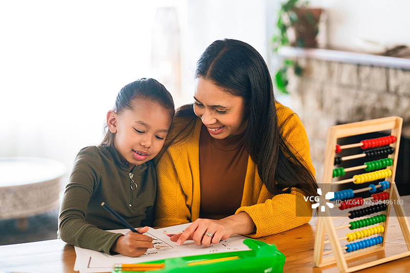 孩子、母亲在家里一起做作业，数学和听取建议的课程。女孩、学生和妈妈在桌子旁进行发展支持，数字和解释加法以获取知识。图片素材