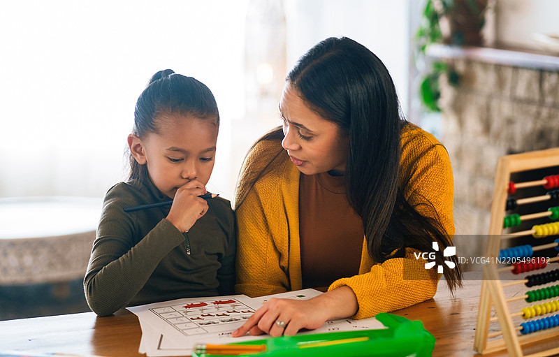 孩子、母亲和家庭数学教育，解决问题并听取建议的课程。女孩、学生和妈妈在桌子旁进行发展支持，数字和解释加法以获取知识。图片素材