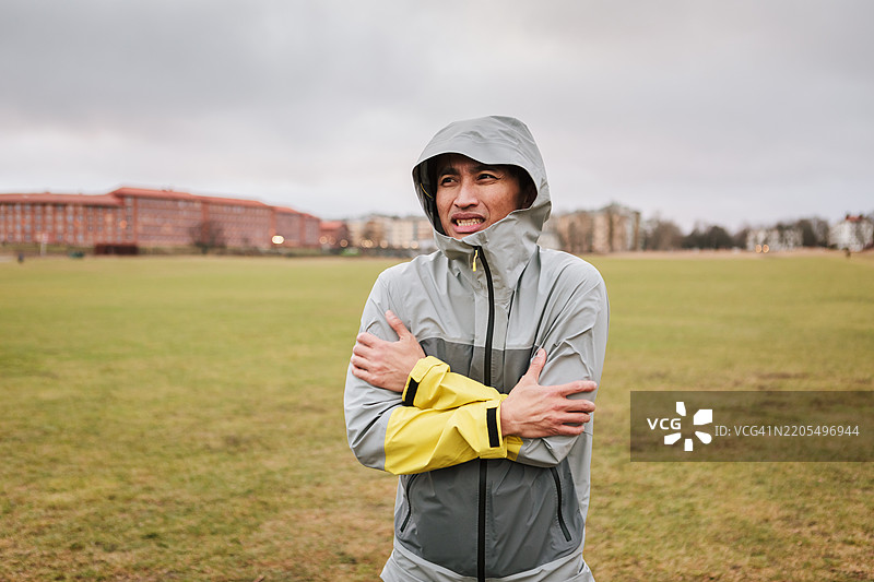 在大城市公园里穿着跑步服的冻僵男子肖像。图片素材