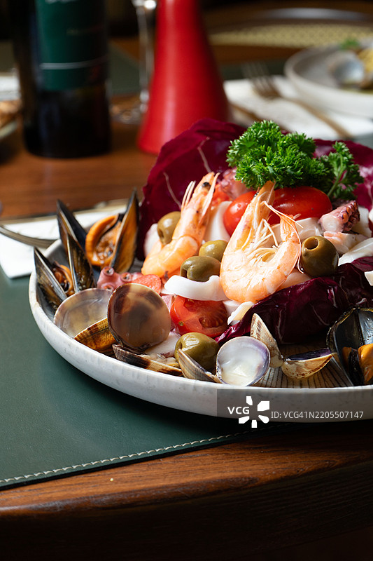 餐厅里的一道混合海鲜菜肴，包含鱼、虾、章鱼和贻贝图片素材