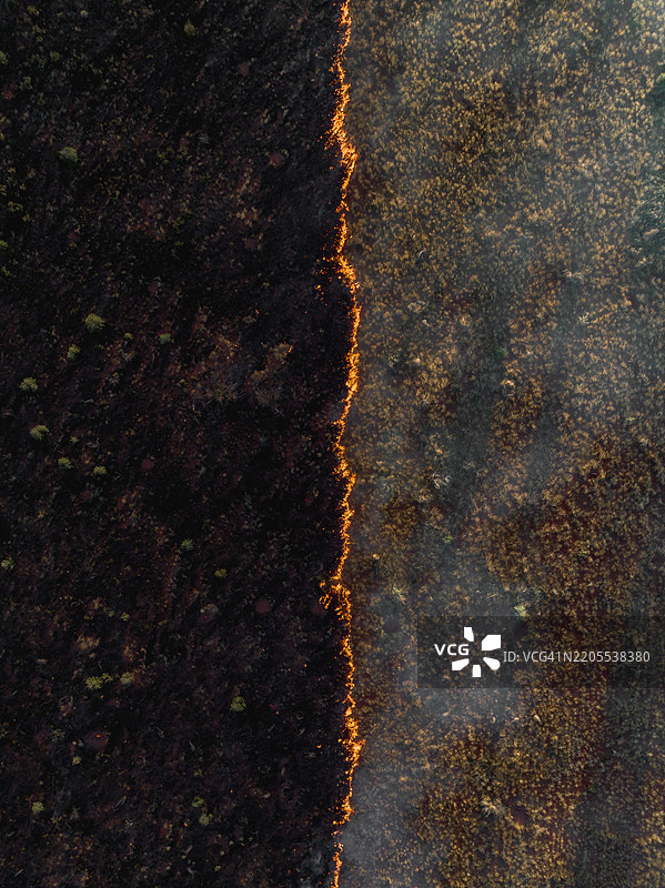 无人机照片展示了澳大利亚北领地塔纳米沙漠边缘烧毁与未烧毁草地之间的对比图片素材