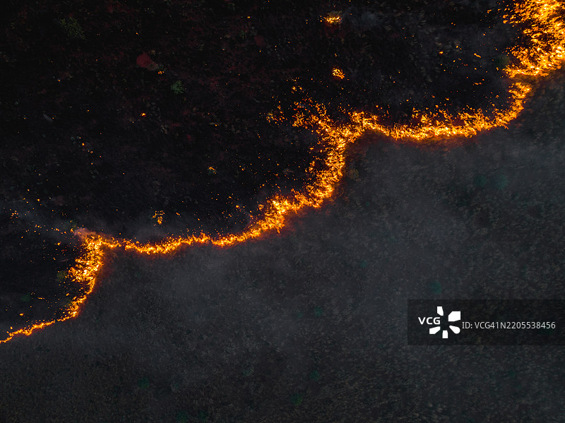 超现实的航拍图像，展示了澳大利亚内陆塔纳米沙漠北部地区一处受控火灾燃烧草原的边缘。图片素材