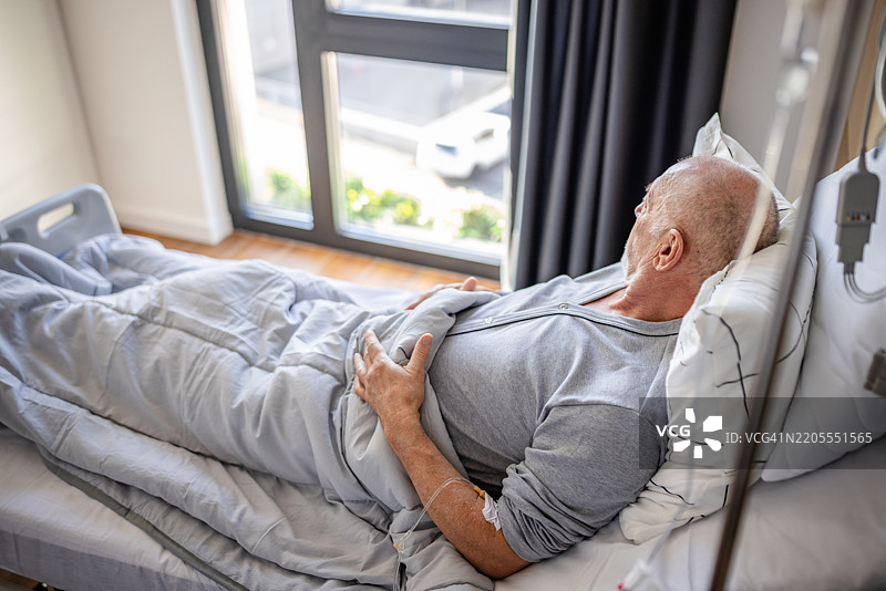 老年人在医院病床上接受医疗专业人员的护理和支持，正在康复中图片素材