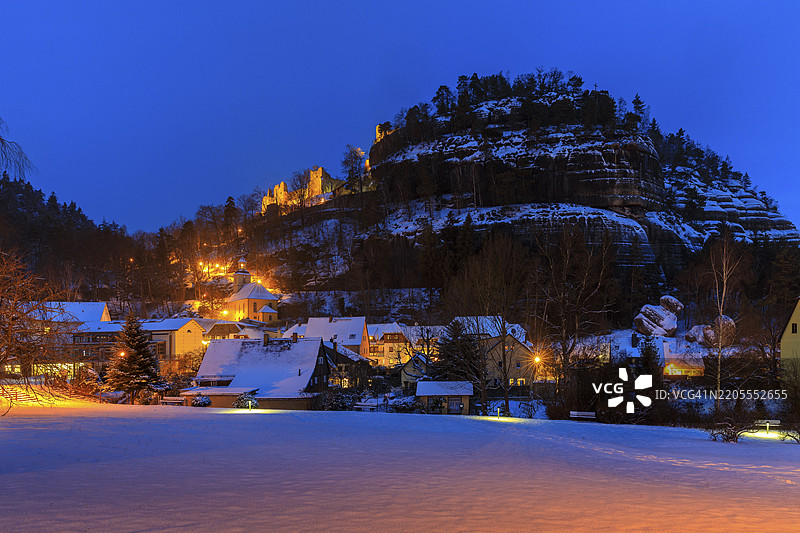 雪中的奥伊宾山景观，山上有废墟和村庄，村庄中有山教堂，位于德国萨克森州齐陶山脉的奥伊宾。图片素材