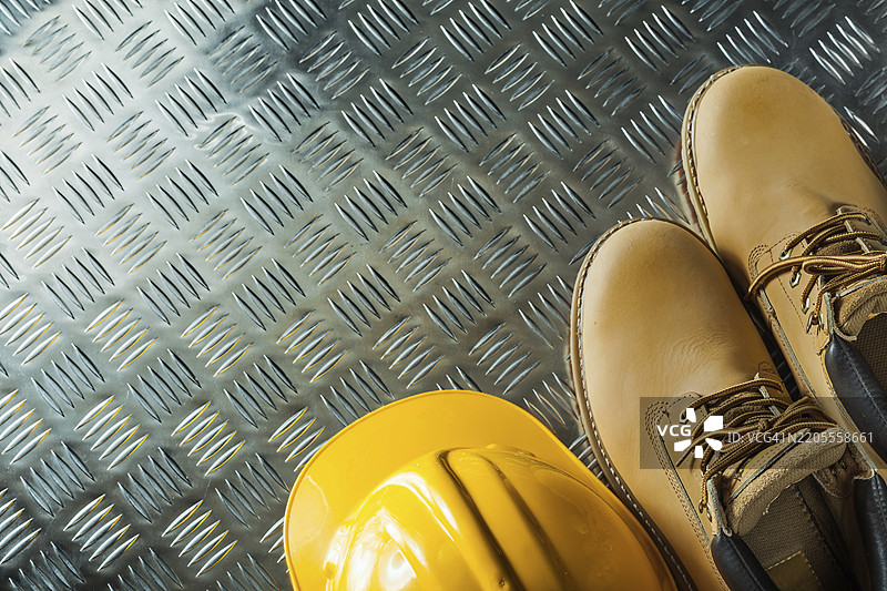 防水靴和安全帽放在波纹金属板上图片素材